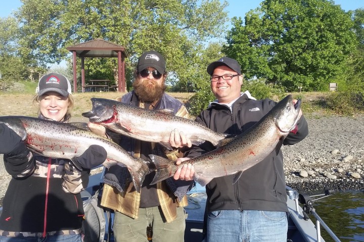 a man posing for the camera with caught fish