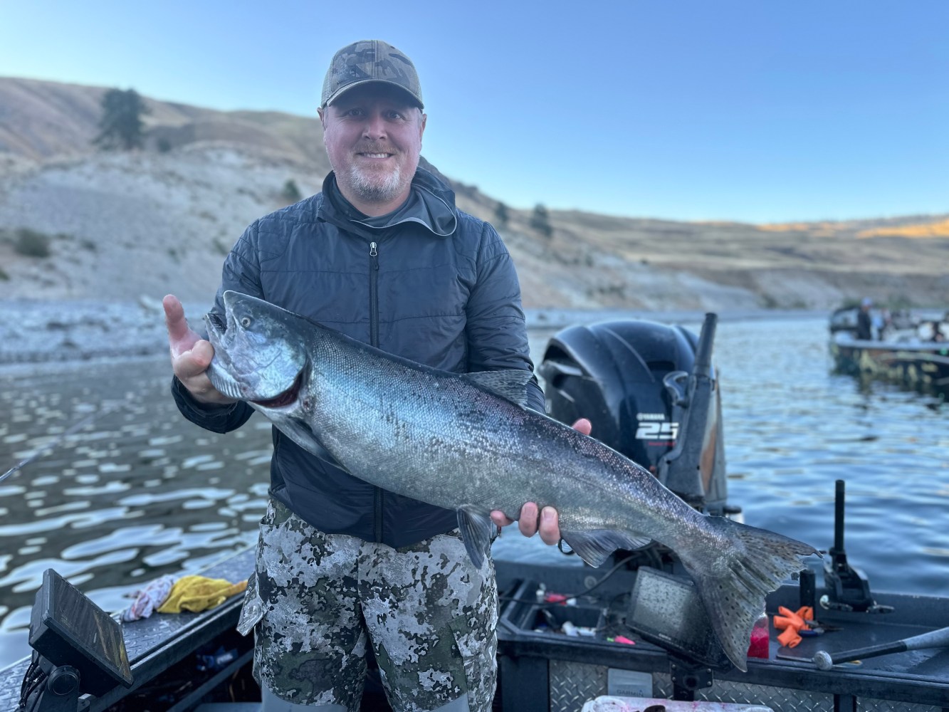 a man holding a fish on a boat